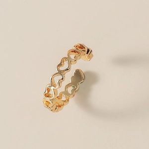 Dettaglio dell'anello aperto dorato a cuore traforato con design di cuori intrecciati
