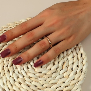 Détail d'une bague coeur en or rose portée à la main avec un décor chaleureux