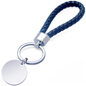 Gros plan d'un porte-clés en cuir tressé bleu avec une médaille ronde à graver