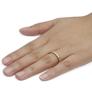 Bague ajustable minimaliste en or avec motifs de cœurs entrelacés portée au doigt
