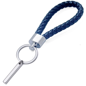 Détail du porte-clés en cuir tressé bleu marine avec pendentif barre carrée argentée