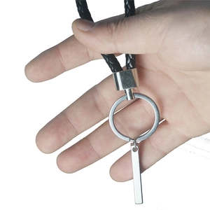 Porte-clés minimaliste en acier inoxydable avec cordon tressé noir tenu à la main