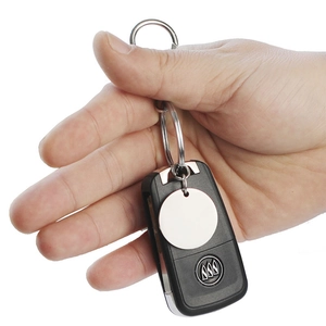 Detailed view of a blank round stainless steel keychain held with a car key