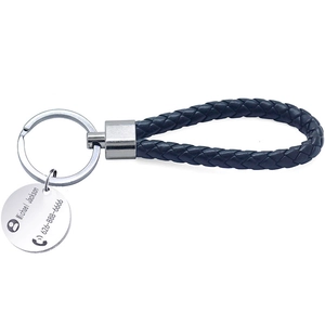 Close-up of a braided leather keychain featuring a custom engraved metal circular plate