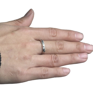 Silver musical note ring with vertical stripe texture worn on finger in a minimalist style