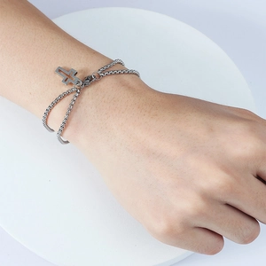 Detail view of double box chain stainless steel bracelet with cross pendant on model
