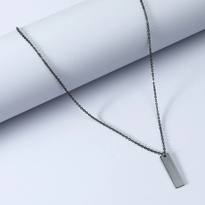 Macro shot of minimalist gunmetal rectangle bar pendant with smooth mirror finish texture