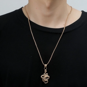 3D gold-tone snake pendant necklace with detailed scales on a black ribbed tee shirt