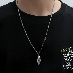 Men's silver spearhead pendant necklace with black beaded chain on black shirt background
