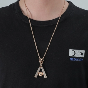 Dettaglio del ciondolo hip hop a forma di mazza da baseball con placcatura oro e cristalli