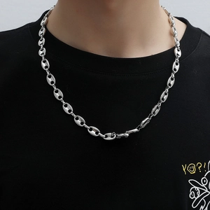 Collier à maillons grain de café argenté poli sur une personne en t-shirt noir graphique
