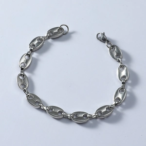 Gros plan du bracelet à maillons grain de café argenté avec fermoir mousqueton sur gris