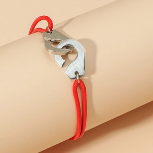 Bracelet minimaliste en corde tressée rouge avec menottes argentées sur support rose
