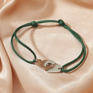 Détail du bracelet réglable en corde de nylon verte avec menottes métalliques croisées