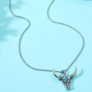 Macro detail of vintage silver bull head pendant featuring a polished blue turquoise stone