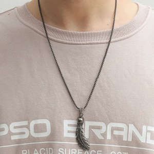 Detail of gothic skull and feather pendant on box chain with matte silver finish