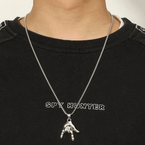 Silver hip hop long chain necklace with rock gesture hand pendant worn on black sweatshirt
