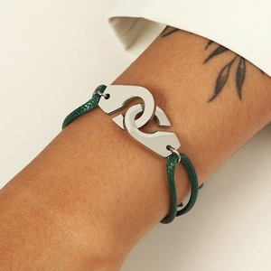 Détail du bracelet en cordon tressé vert réglable avec menottes en acier inoxydable