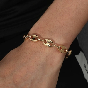 Gros plan d'un bracelet maille grain de café doré au poignet pour un style hip hop chic