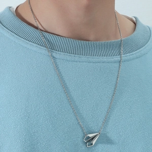 Modern titanium steel paper plane necklace for men on a blue knit sweater background