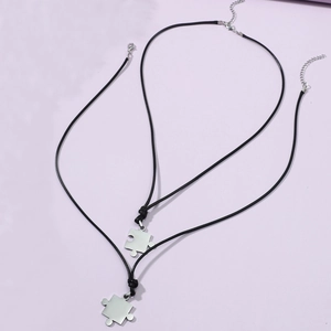 Paire de pendentifs en forme de puzzle en acier inoxydable avec cordons en cuir noir
