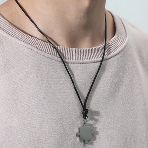 Collier avec pendentif puzzle minimaliste en acier inoxydable sur cordon noir réglable
