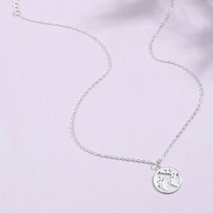 Collier mappemonde en argent avec pendentif globe évidé sur fond violet élégant