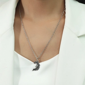 Retro silver moon face pendant necklace on model with vintage engraved moon charm detail