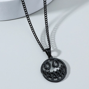 Nahaufnahme des schwarzen hohlen Smiley-Anhängers an einer Metallkette im Punk-Stil