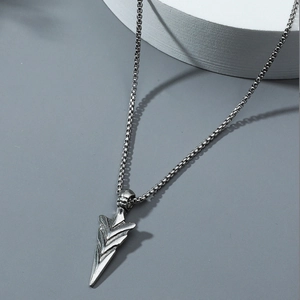 Gros plan sur un pendentif pointe de flèche argent vintage avec chaîne pour hommes