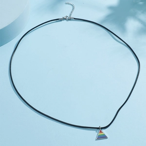 Pendentif triangle arc-en-ciel en acier titane avec cordon ciré noir sur fond bleu doux