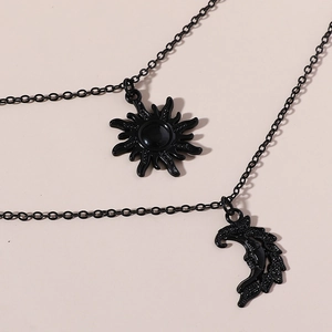 Detailed macro view of black double-layer necklace with sun and moon moon charms
