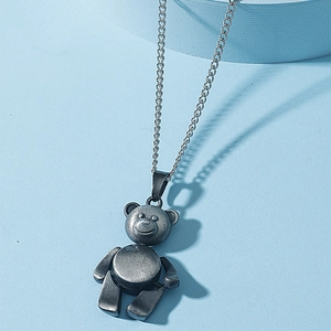Collier avec pendentif ours mécanique vintage argenté sur fond bleu clair
