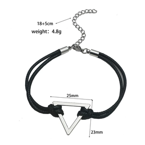 Detail of black woven leather cord bracelet with silver triangle pendant and lobster clasp