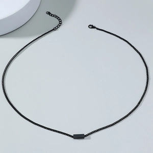 Close-up of minimalist black cube pendant with thin chain and adjustable lobster clasp