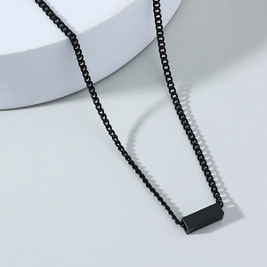 Detail of a matte black rectangular pendant on a black Cuban chain for a hip-hop look