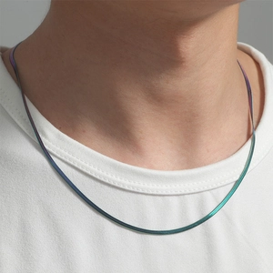 Close-up of 8mm rainbow titanium steel twist chain necklace worn on a white t-shirt
