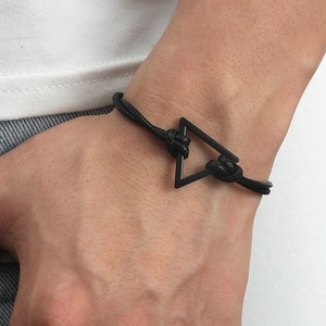 Close-up of minimalist black braided leather bracelet with triangle metal buckle