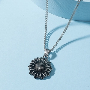 Retro silver sunflower pendant necklace with detailed petals on a light blue background