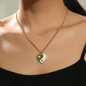 Detailaufnahme des herzförmigen Yin-Yang-Anhängers in Grün-Weiß an einer Goldkette