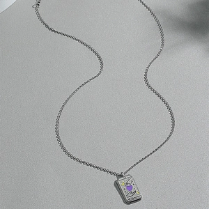 Vintage silver tarot pendant necklace with crescent moon and purple heart on sand background