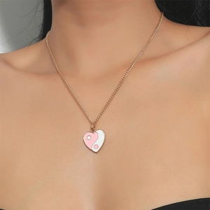 Detailansicht eines rosa-weißen Herz-Yin-Yang-Anhängers an einer goldenen Gliederkette