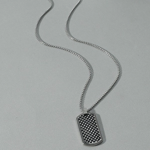 Detailed view of rectangular military tag pendant with black and white textured pattern