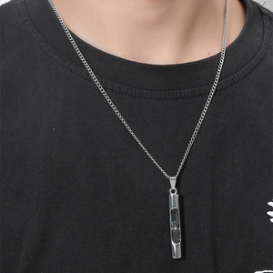 Collier sablier minimaliste avec sable noir dans un cylindre clair sur chaîne argentée
