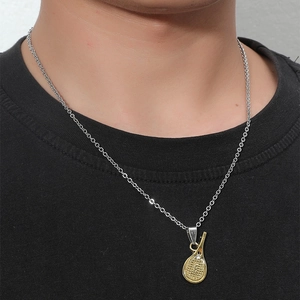 Détail du pendentif raquette de tennis doré avec cristal sur une chaîne argentée