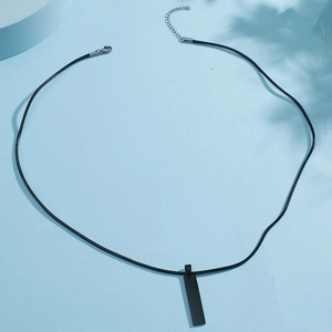 Macro detail of a minimalist matte black bar pendant with a braided leather cord necklace