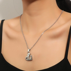 Collier avec pendentif coeur argenté poli et gravure LOVE porté par un mannequin