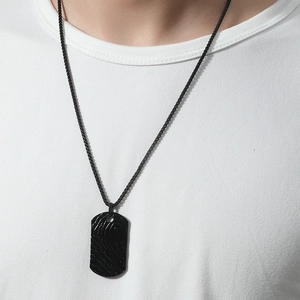 Detailed close-up of a black dog tag necklace with a unique fingerprint texture