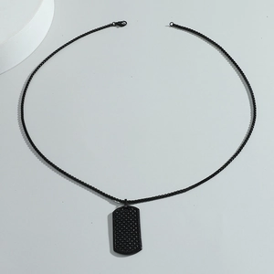 Men's hip hop black metal dog tag necklace with textured matte pendant on flat background
