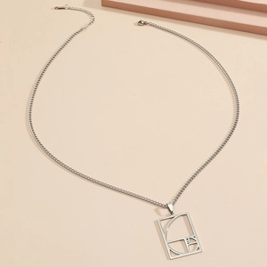 Macro detail of geometric hollow square pendant with Fibonacci spiral on silver chain